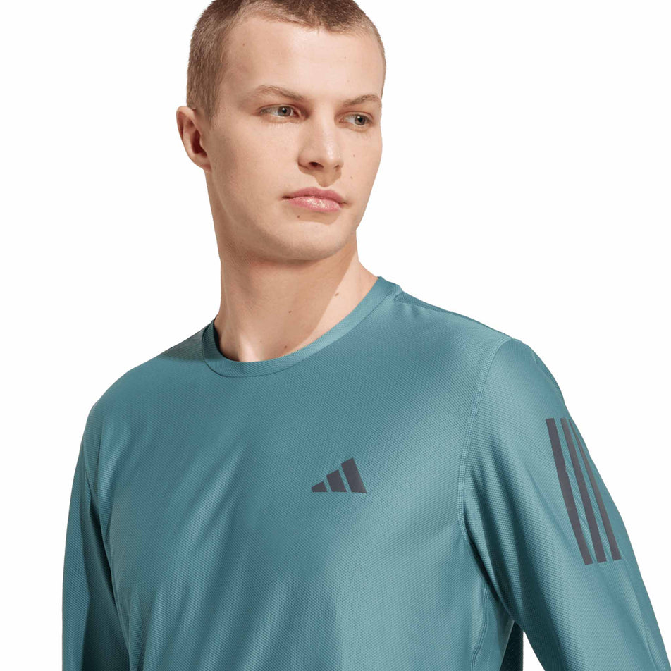 Front view of a model wearing the adidas Men's Own The Run Base Long Sleeve in the Preloved Teal colourway. (8751018180770)
