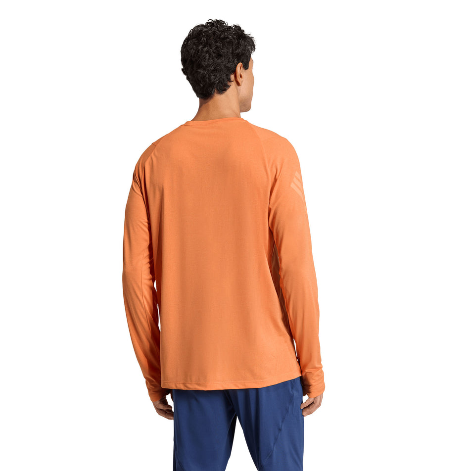 Back view of a model wearing the adidas Men's adi365 Long Sleeve in the Dusky Orange colourway.