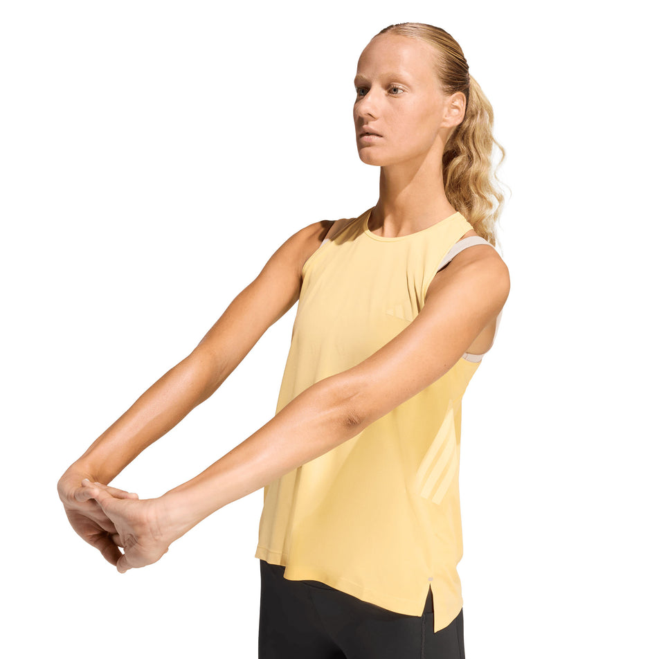 Angled view of a model wearing the adidas Women's adi365 Climacool Tank Top in the Semi Ice Tangerine colourway.