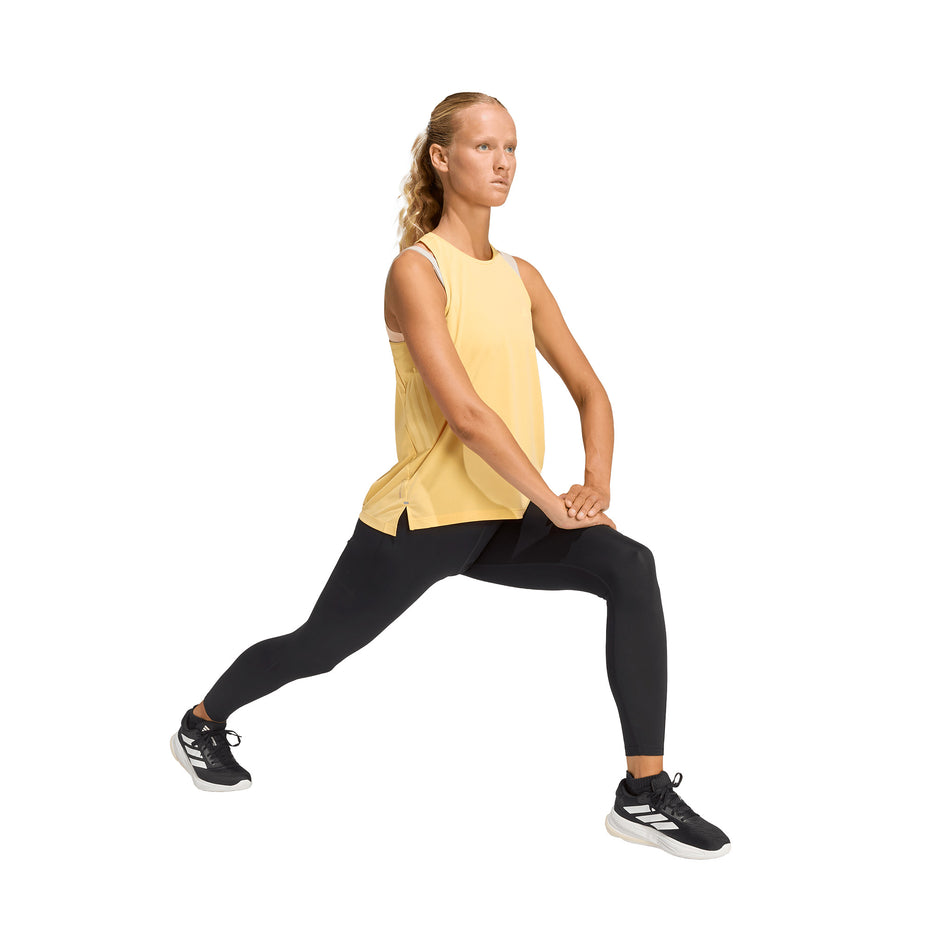 Angled view of a model wearing the adidas Women's adi365 Climacool Tank Top in the Semi Ice Tangerine colourway.