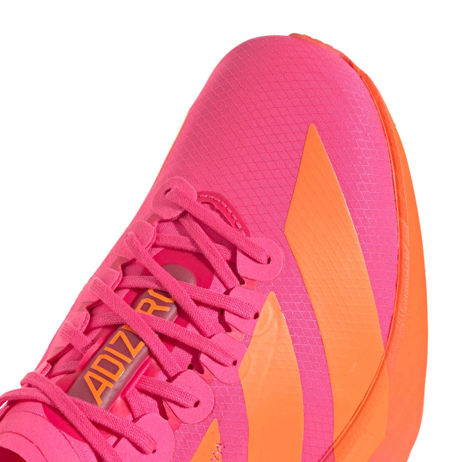 Close-up view of the toe box of the right shoe from a pair of adidas Men's Adizero Adios Pro 4 Running Shoes in the Lucid Pink/Lucid Orange/Iron Met. colourway.