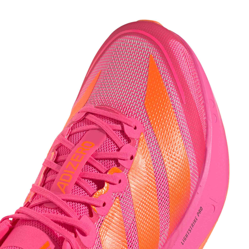 Close-up view of the toe box of the right shoe from a pair of adidas Men's Adizero Boston 13 Running Shoes in the Lucid Pink/Lucid Orange/Iron Met. colourway.