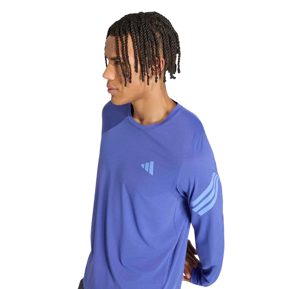 Angled view of a model wearing the adidas Men's adi365 Long Sleeve Running Top in the Dual Indigo. colourway.