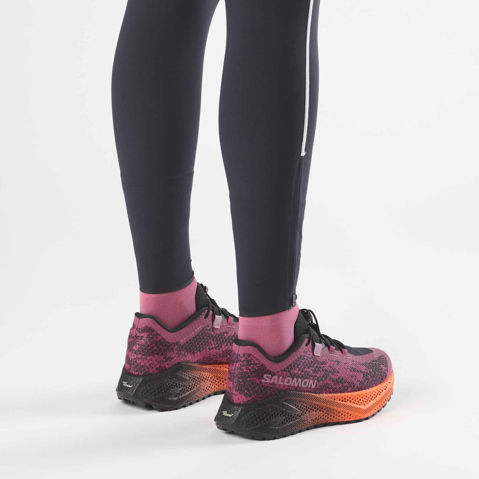 A model wearing a pair of Salomon Women's Aero Glide 4 GRVL Running Shoes in the Nocturne/Black colourway.