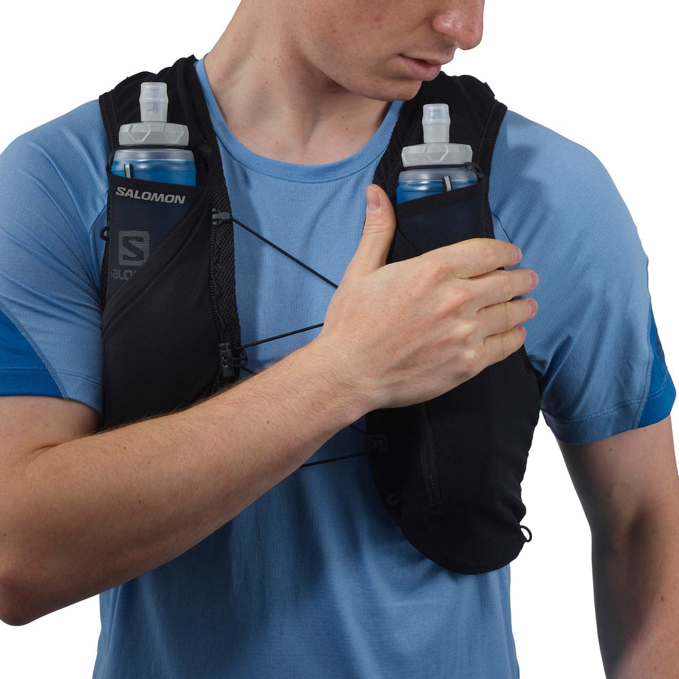 Front view of a model wearing a Salomon Unisex ADV Skin 5 Running Vest in the Black/Ebony colourway, with flasks included. (7991863115938)