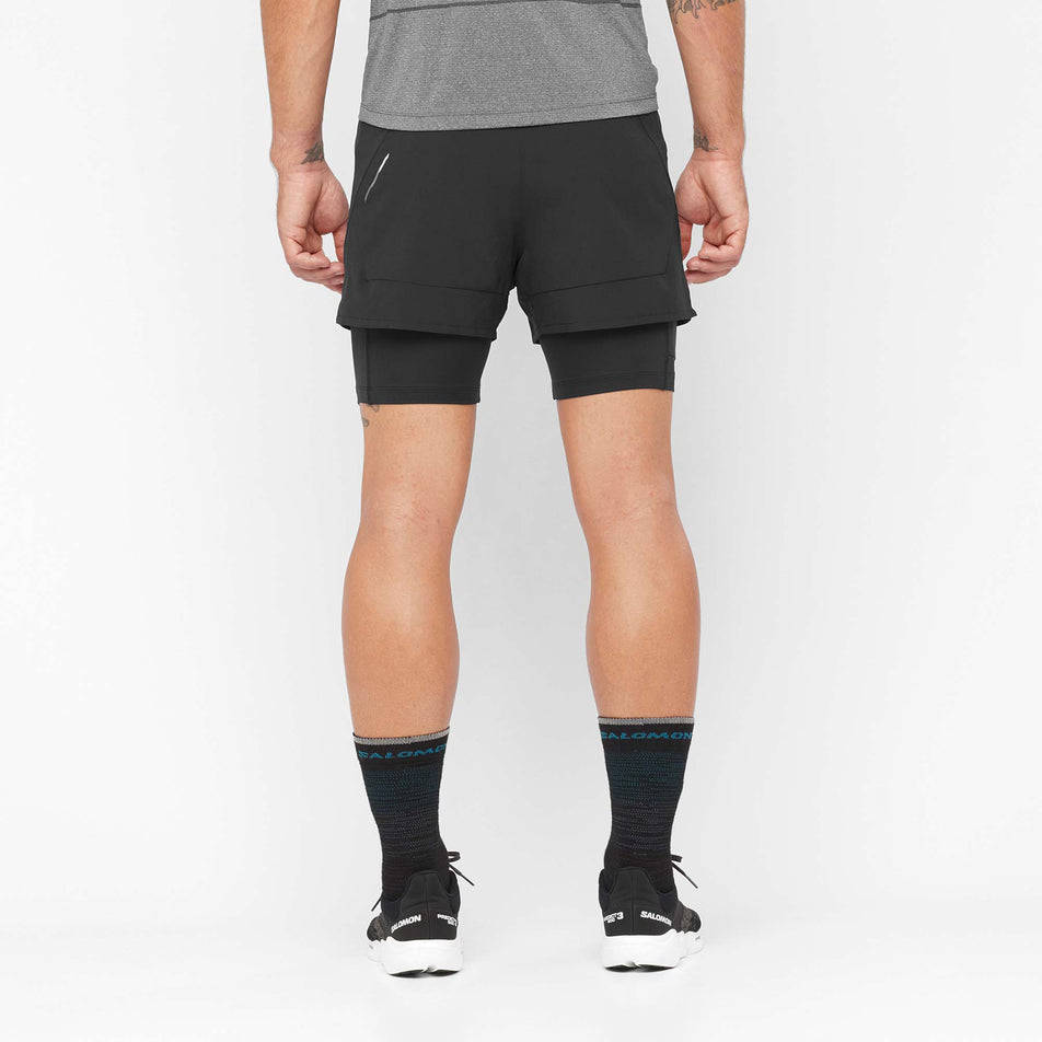 Back view of a model wearing a pair of Salomon Men's Cross 2in1 Shorts in the Deep Black colourway (8008550121634)