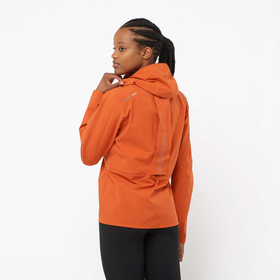 Back view of a model wearing a Salomon Women's Bonatti Trail Jacket in the Burnt Ochre colourway (8000727351458)