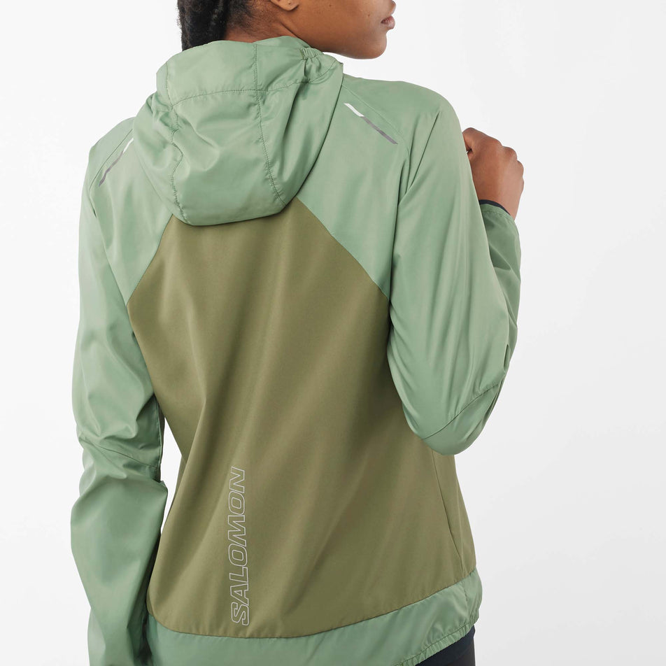 Close-up back view of a model wearing a Salomon Women's Bonatti Cross Wind Jacket in the Lily Pad/Deep Lichen Green colourway. (7999055462562)
