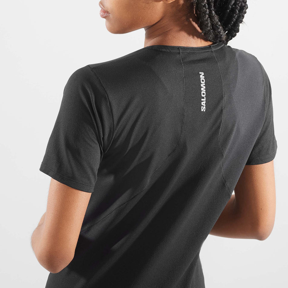 Close-up back view of a model wearing a Salomon Women's Sense Aero Short Sleeve T-Shirt in the Deep Black colourway (8000768901282)