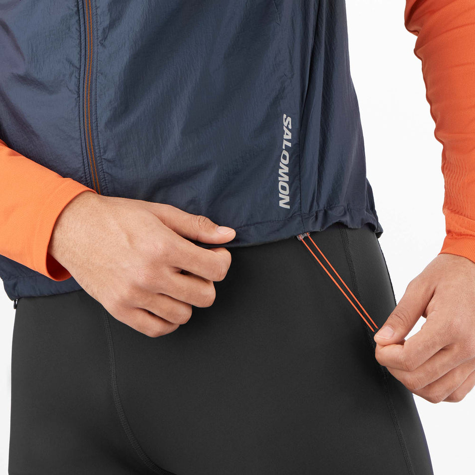 A model demonstrating the elasticated adjustment cord at the waist section of a Salomon Men's Sense Flow Vest (8071113769122)