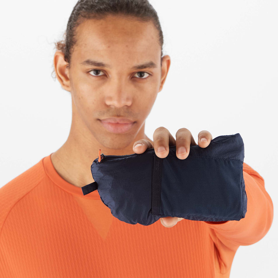 A model demonstrating that a Salomon Men's Sense Flow Vest can be packed into its pocket (8071113769122)
