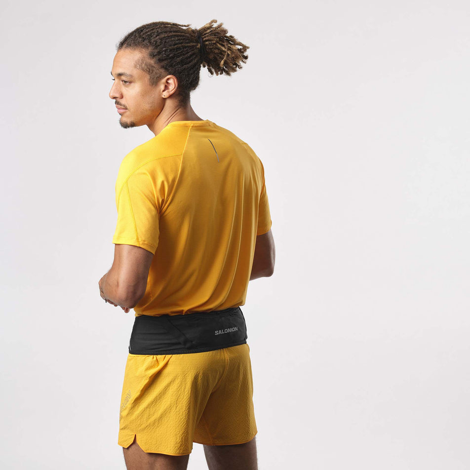 Back view of a model wearing a Salomon Unisex Pulse Belt in the Black colourway. Model is also wearing a running top and running shorts. (8151604297890)