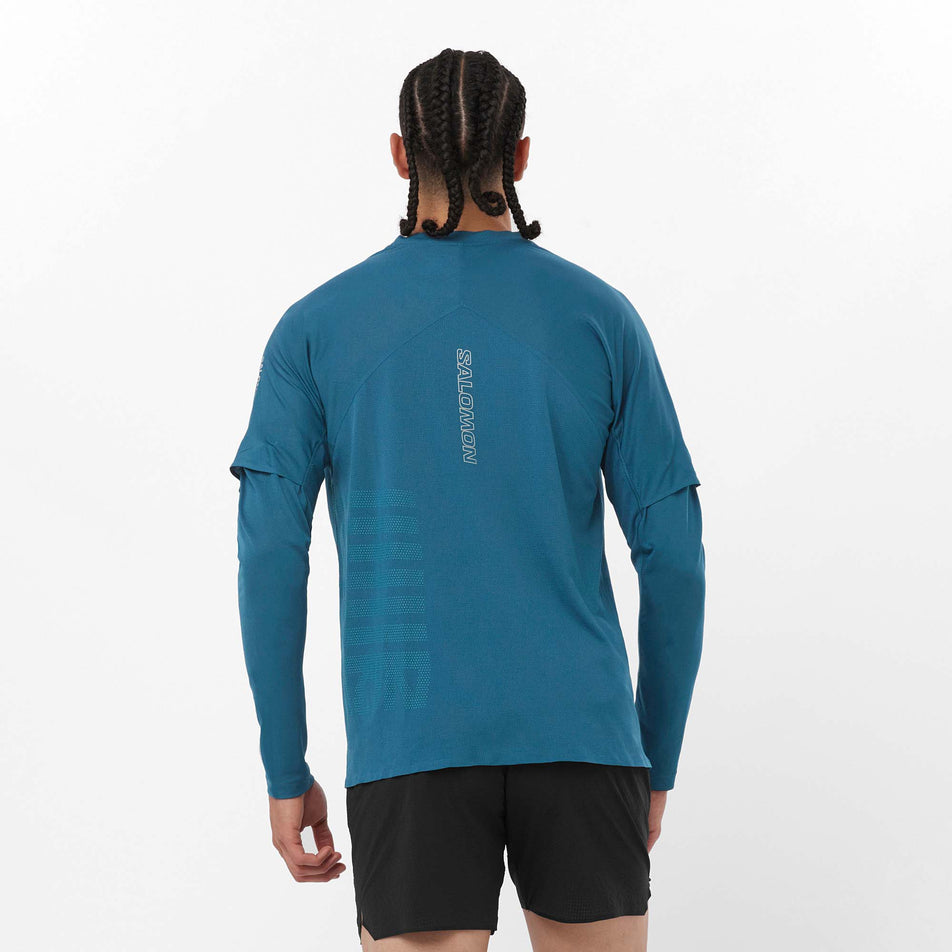 Back view of a model wearing a Salomon Men's Sense Aero GFX Long Sleeve T-Shirt in the Deep Dive/Tahitian Tide colourway. Model is also wearing Salomon shorts. (8157822812322)