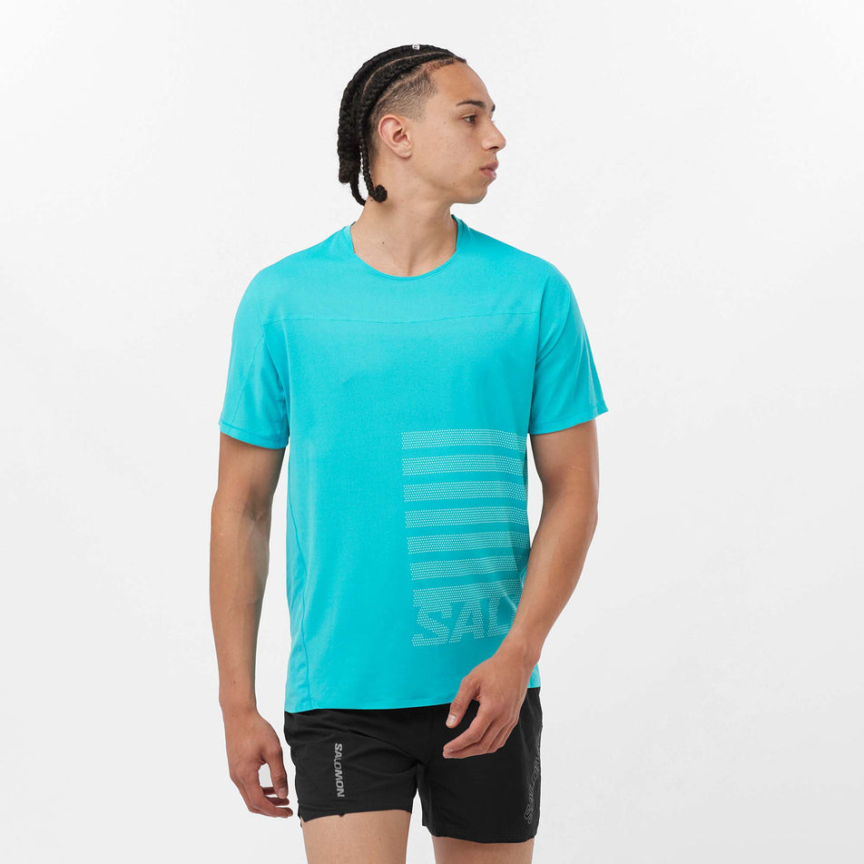 Front view of a model wearing a Salomon Men's Sense Aero GFX Short Sleeve T-Shirt in the Peacock Blue/White colourway. Model is also wearing Salomon shorts. (8157825466530)