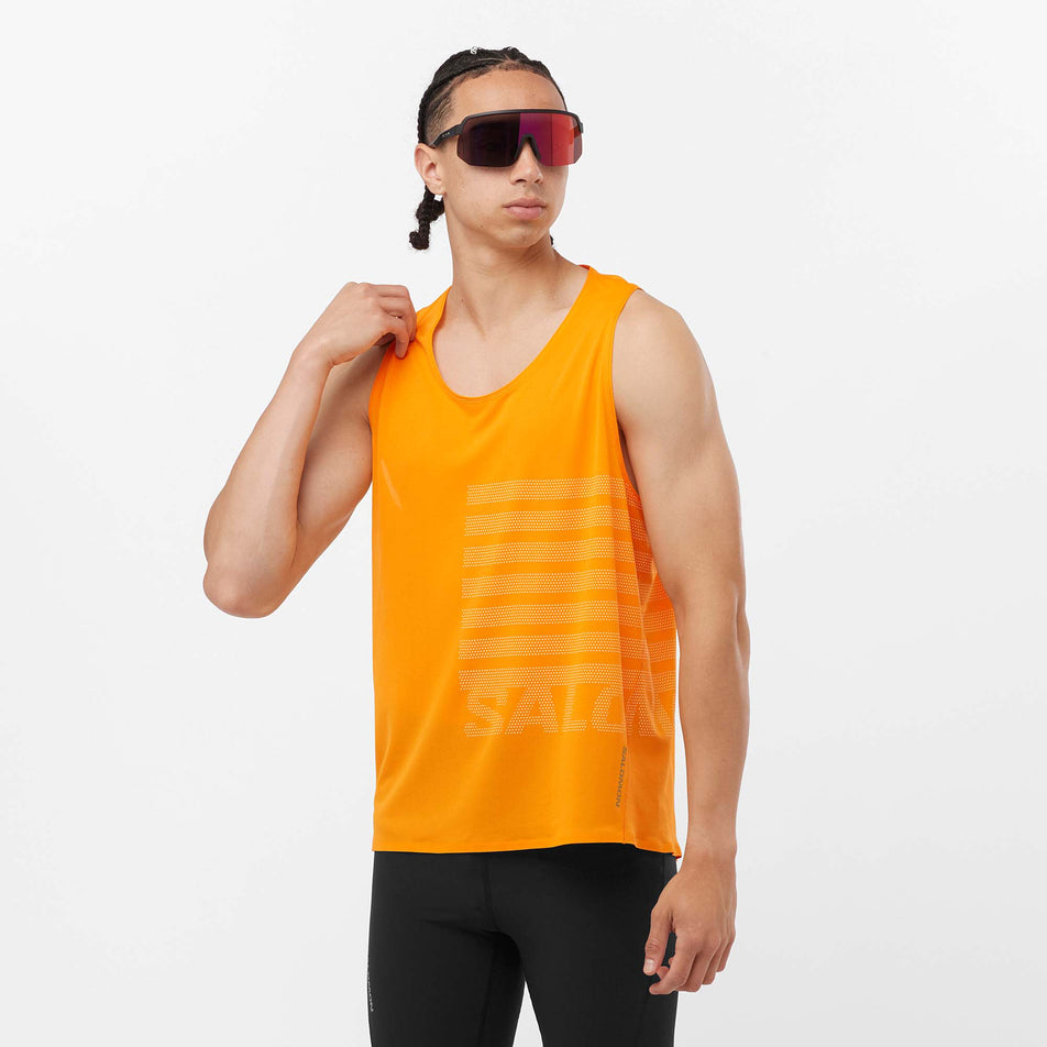 Front view of a model wearing a Salomon Men's Sense Aero GFX Singlet in the Zinnia/White colourway. Model is also wearing sunglasses and leggings. (8311786799266)