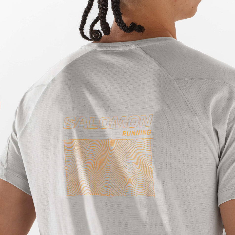 Close-up view of the graphic on the back of a Salomon Men's Cross Run GFX Tee in the Gray Violet colourway. Top is being worn by a model. (8311807705250)