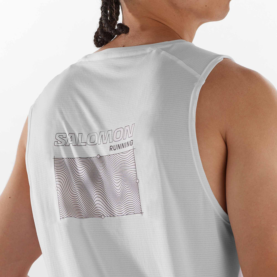 Close-up view of the graphic on the back of a Salomon Men's Cross Run Tank GFX in the White colourway. Top is being worn by a model.  (8246399729826)