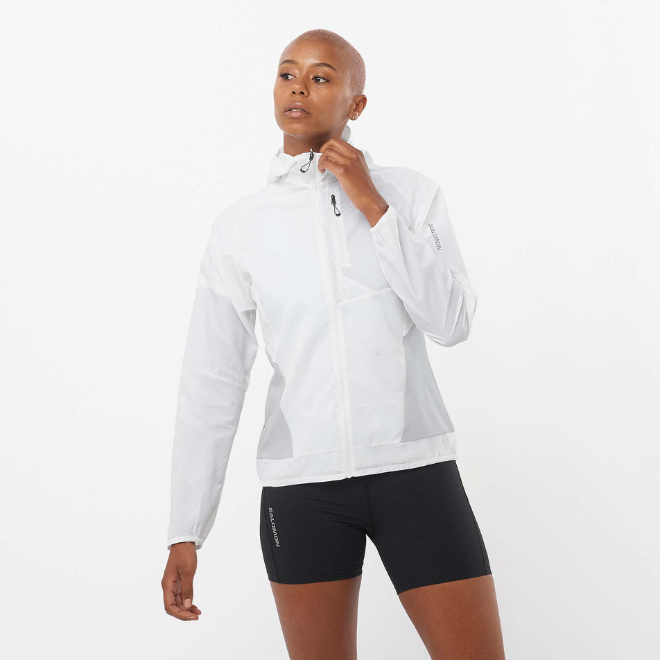 Front view of a model wearing a Salomon Women's Bonatti Cross Wind Jacket in the White/Gray Violet colourway. Model is also wearing Salomon shorts.  (8157867016354)