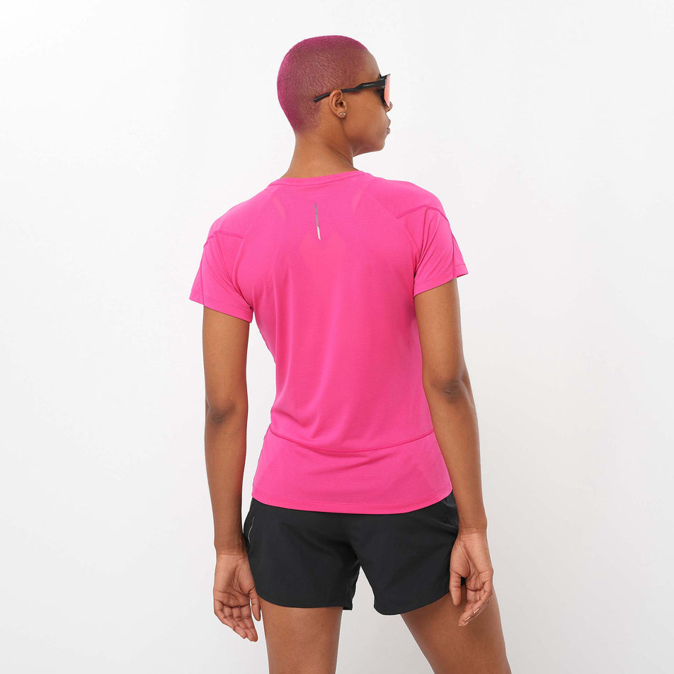 Back view of a model wearing a Salomon Women's Cross Run Short Sleeve T-Shirt in the Beetroot Purple colourway. Model is also wearing Salomon running shorts. (8157877502114)
