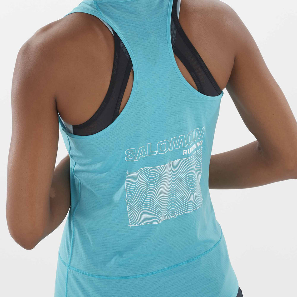 Close-up view of the graphic on the back of a Salomon Women's Cross Run GFX Tank in the Peacock Blue colourway.Top is being worn by a model. (8311912202402)