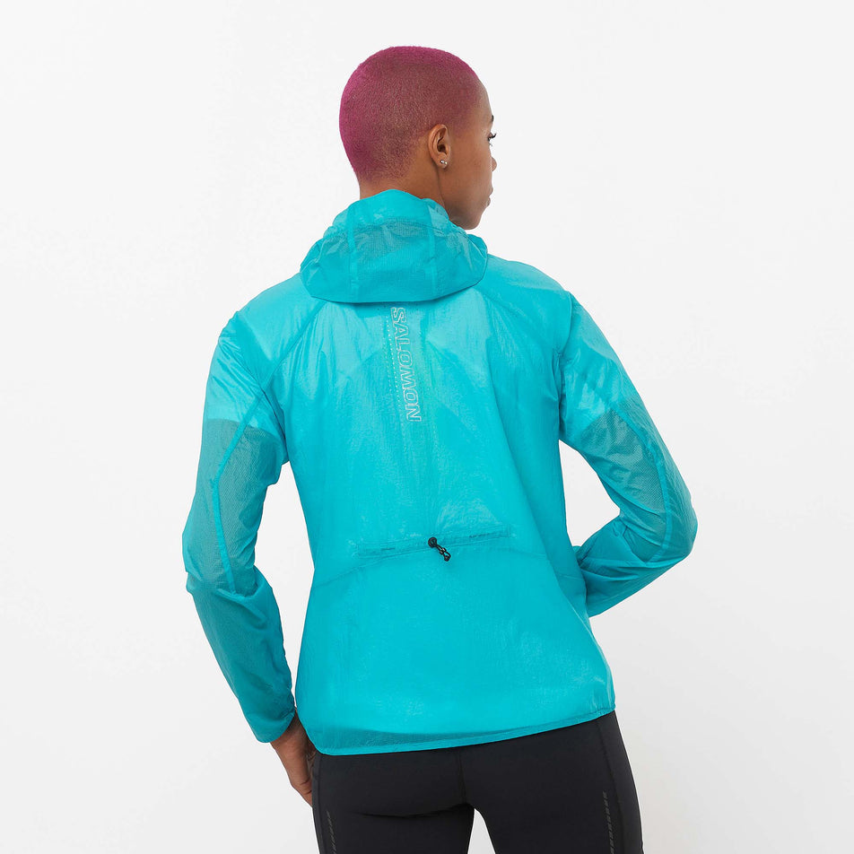 Back view of a model wearing a Salomon Women's Sense Aero Wind Jacket in the Peacoat Blue colourway. Model is also wearing Salomon shorts. (8157861871778)