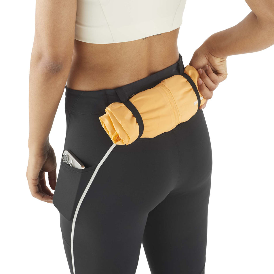 A model demonstrating the storage options of the Salomon Women's Sense Aero Stow Tights in the Deep Black colourway. (8727044685986)