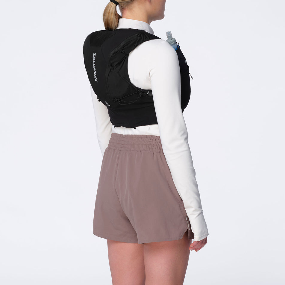 Angled view of model wearing the Salomon Women's ADV Skin 12 Set Running Vest in the Black/Asphalt colourway.