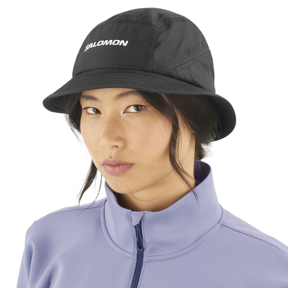 Front view of a model wearing the Salomon Unisex SHKout Bucket Hat in the Deep Black colourway. (8577875476642)