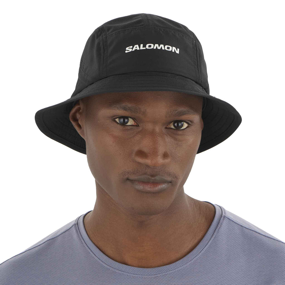 Front view of a model wearing the Salomon Unisex SHKout Bucket Hat in the Deep Black colourway. (8577875476642)