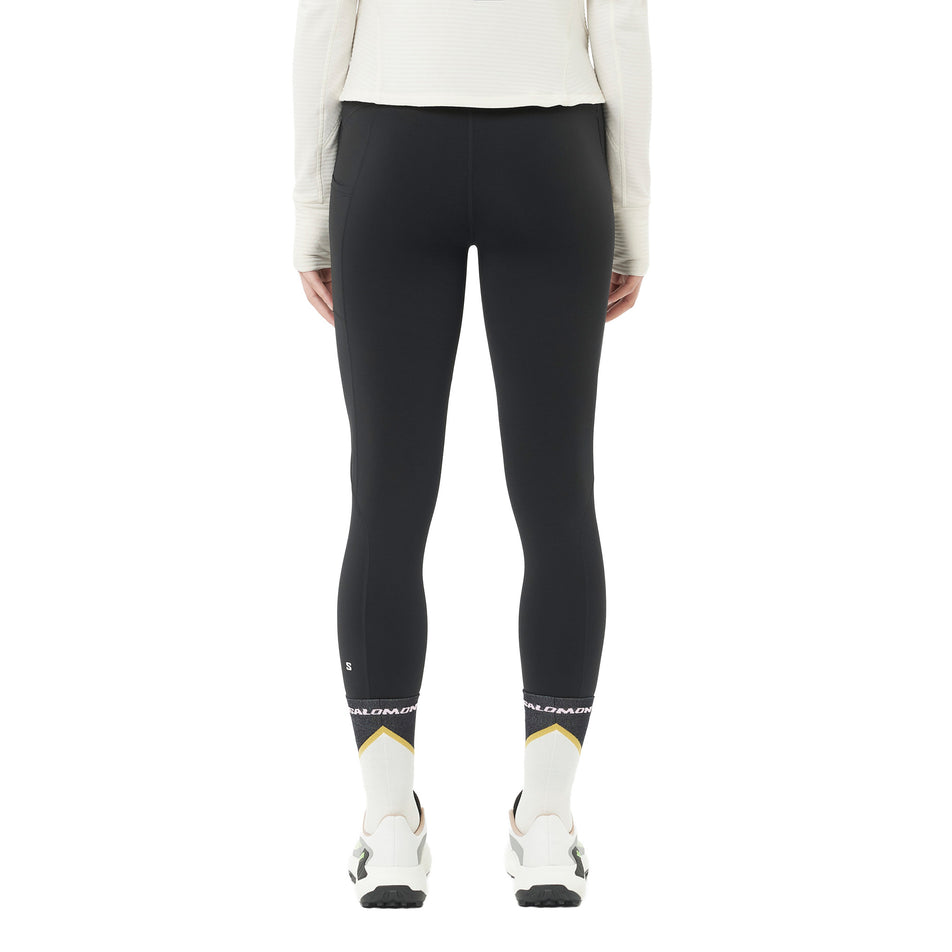 Back view of a model wearing the Salomon Women's SHAKEout Core Warm Tights in the Deep Black colourway. (8781930561698)