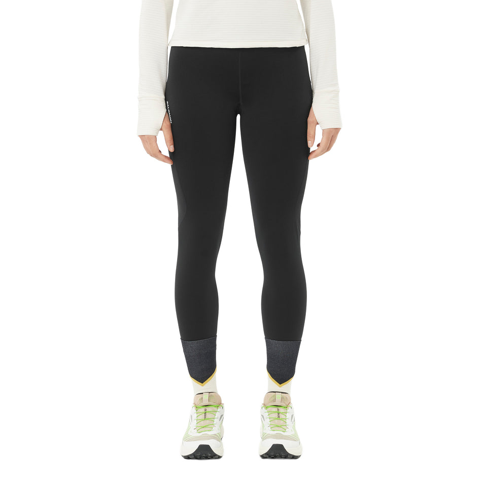 Front view of a model wearing the Salomon Women's SHAKEout Core Warm Tights in the Deep Black colourway. (8781930561698)