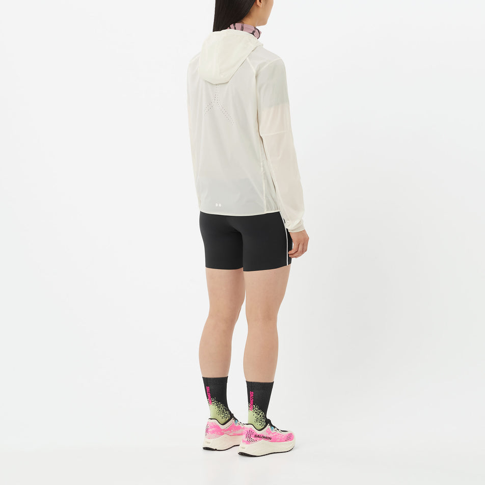 Back view of a model wearing the Salomon Women's Sense Aero Wind Jacket in the Whisper White colourway.