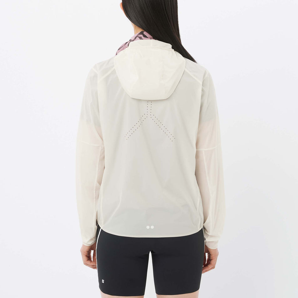 Back view of a model wearing the Salomon Women's Sense Aero Wind Jacket in the Whisper White colourway.