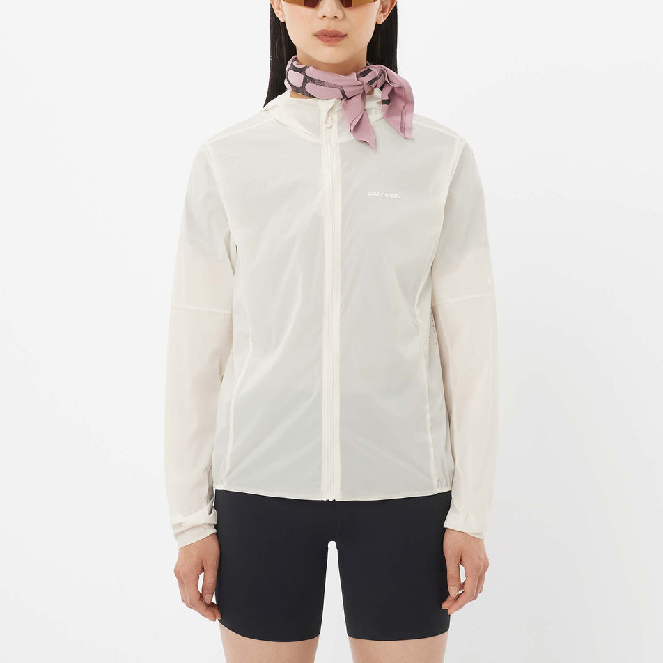 Front view of a model wearing the Salomon Women's Sense Aero Wind Jacket in the Whisper White colourway.