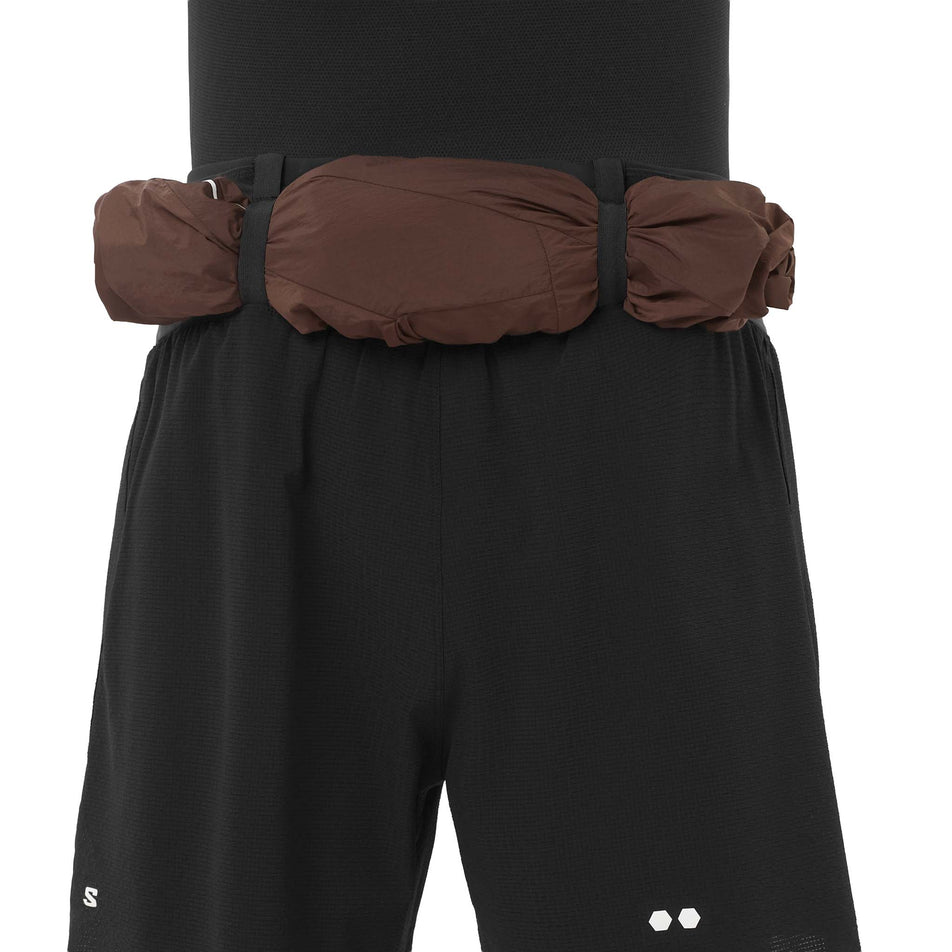 A jacket stowed in the storage loops on the back of the Salomon Men's Sense Aero 2in1 Trail Shorts 5