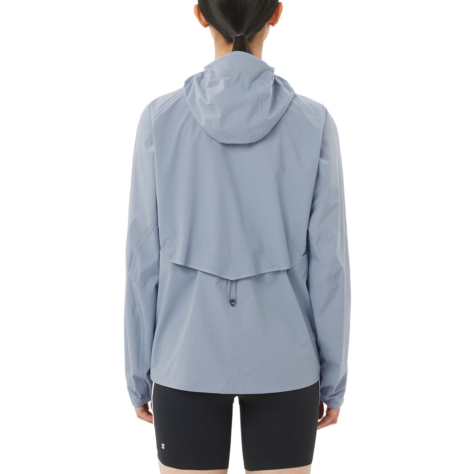 Back view of a model wearing the Salomon Women's Bonatti Waterproof Jacket in the Trade Winds colourway.