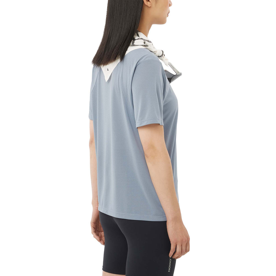 Angled view of a model wearing the Salomon Women's SHKout Core SS Tee in the Trade Winds colourway.