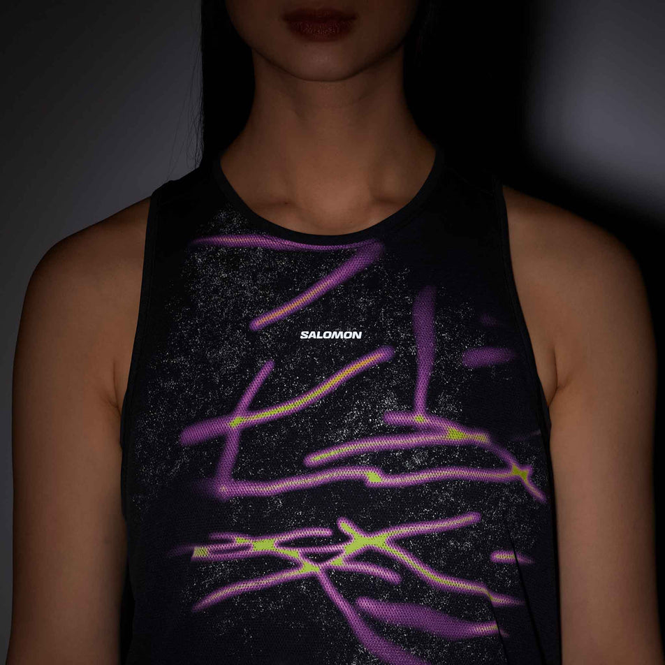 Front view of a model wearing the Salomon Women's SHKout Core Tank GFX in the Deep Black colourway.