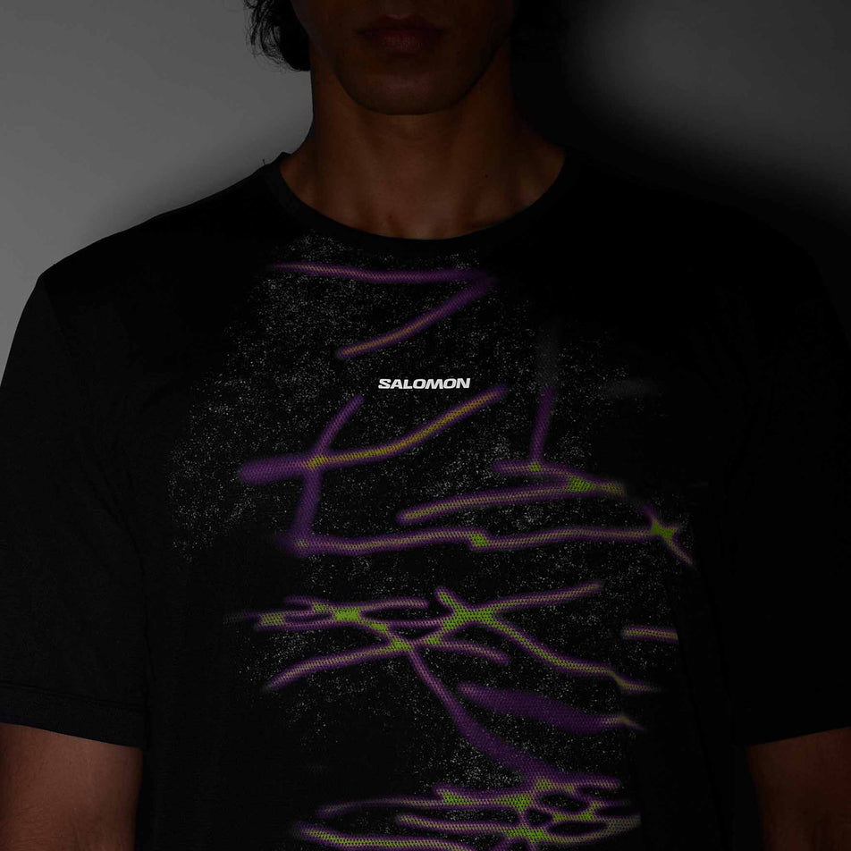 Front view of a model wearing the Salomon Men's SHKout Core SS Tee GFX in the Deep Black colourway.