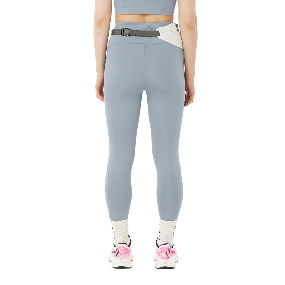 Back view of a model wearing the Salomon Women's SHKout Core Tights in the Trade Winds colourway.
