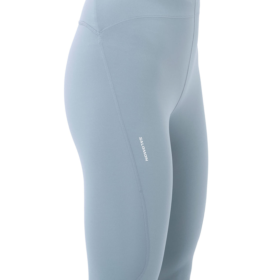 Angled view of a model wearing the Salomon Women's SHKout Core Tights in the Trade Winds colourway.