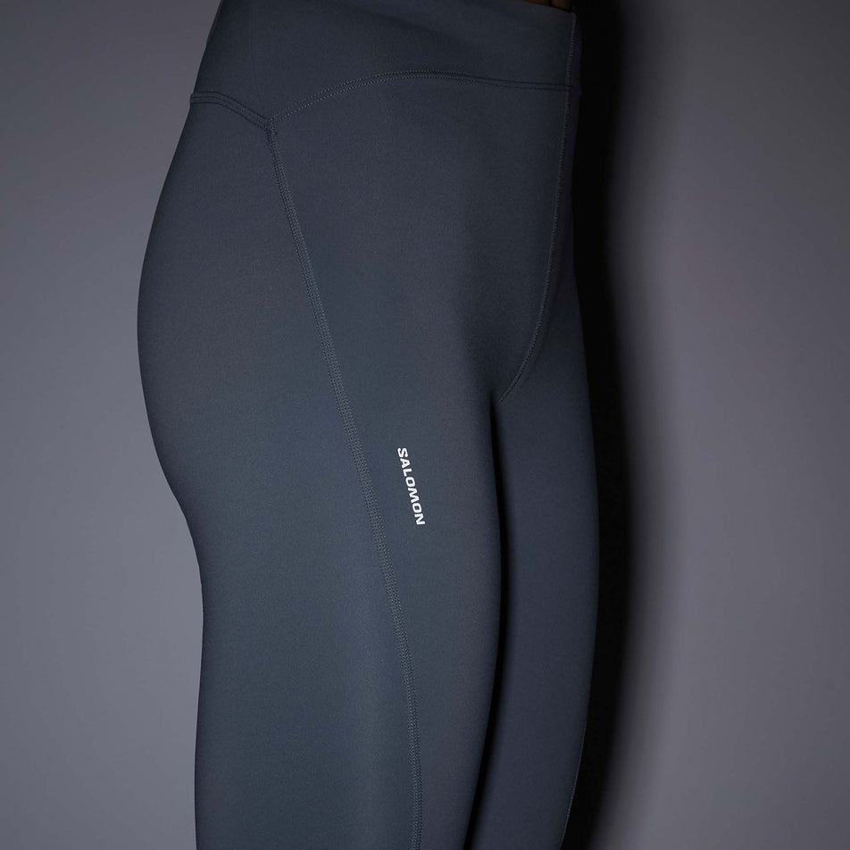 The reflective Salomon logo on the Salomon Women's SHKout Core Tights in the Trade Winds colourway.