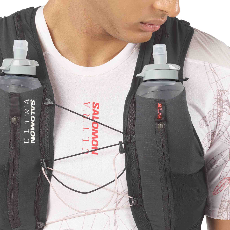 Front view of a model wearing the Salomon Unisex S/LAB Ultra 12 Running Vest in the Black colourway.