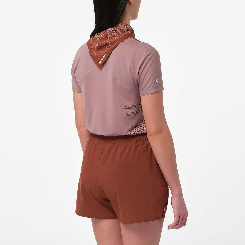 Back view of a model wearing the Salomon Women's Sense Aero SS Tee GFX in the Antler/Chocolate Fondant colourway.