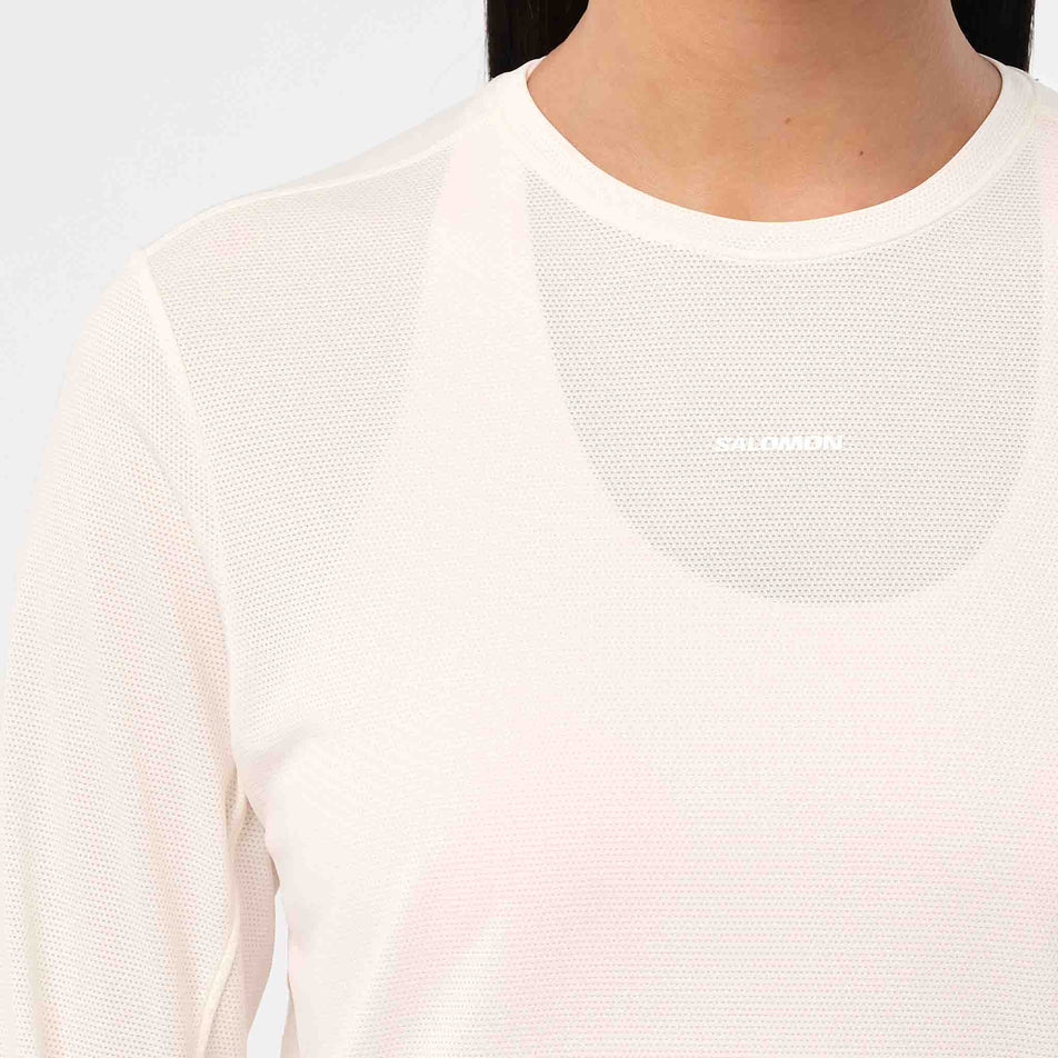 Front view of a model wearing Salomon Women's Shakeout Core LS Tee GFX in the Whisper White/Pink Frosting colourway.