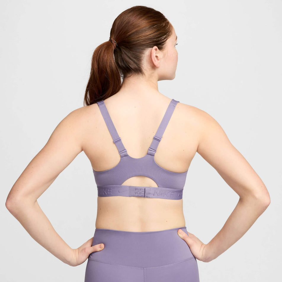 Back view of a model wearing a Nike Women's Indy High Support Padded Adjustable Sports Bra in the Daybreak/Daybreak colourway. (8215845961890)