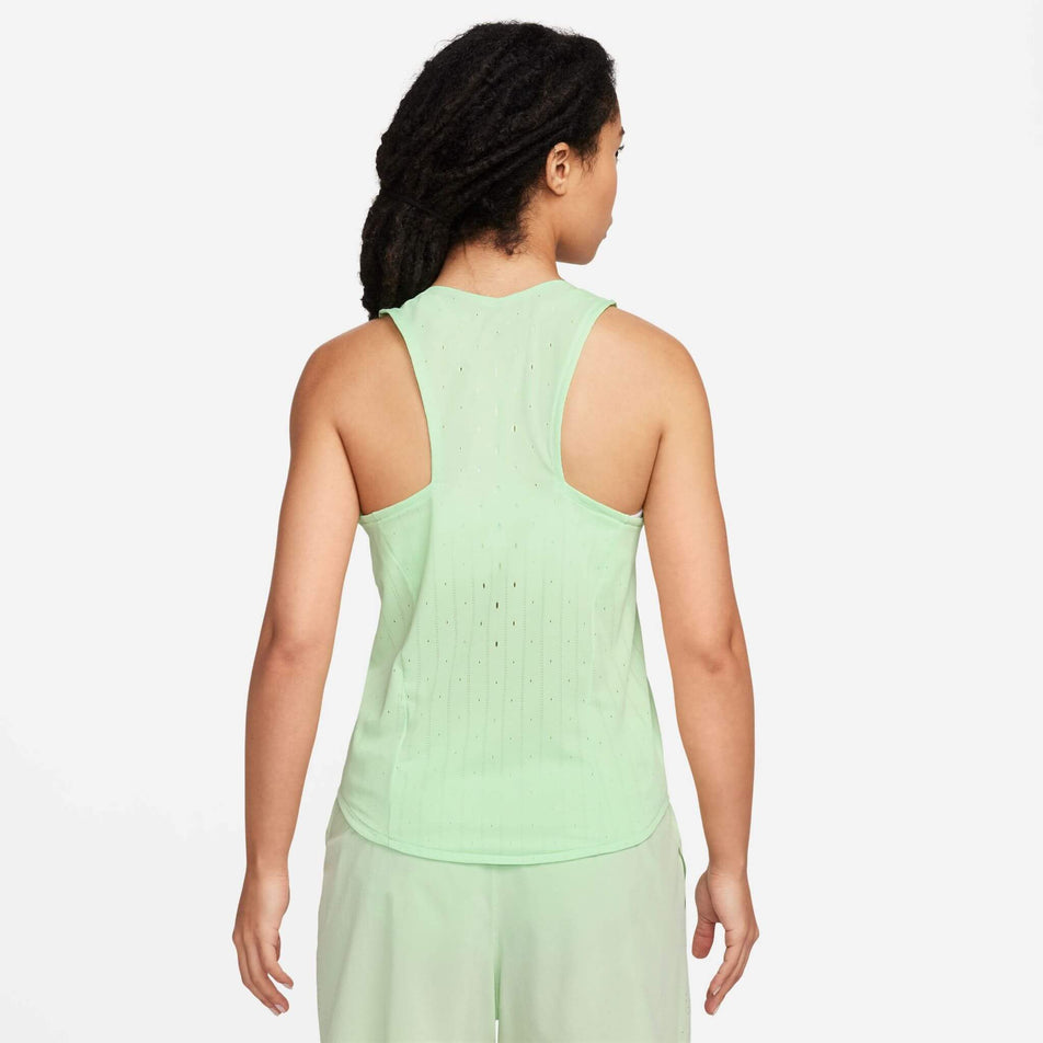 Back view of a model wearing the Women's AeroSwift Dri-FIT ADV Running Singlet in the Vapor Green/Black colourway. Model is also wearing Nike shorts. (8186003357858)