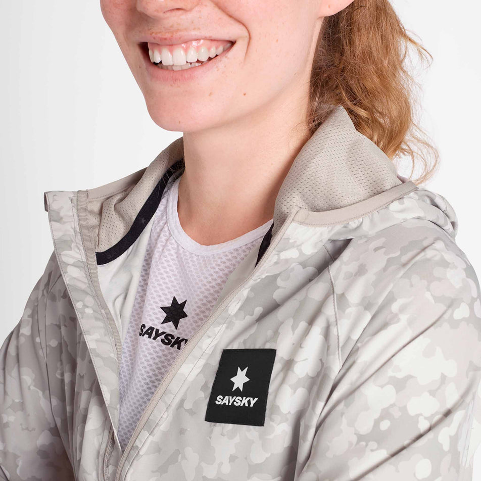 Angled view of a model wearing the SAYSKY Women's Camo Pace Jacket in the White colourway. (8781025869986)
