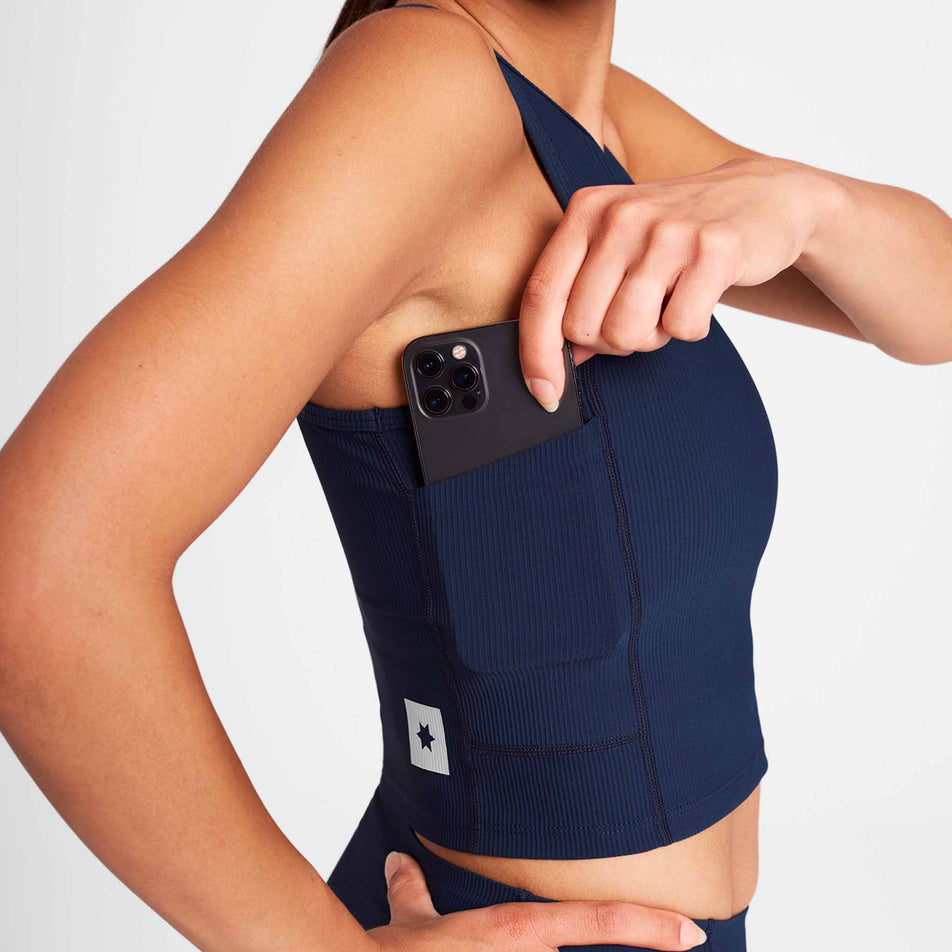 A model demonstrating the pocket on the side of the SAYSKY Women's Combat Rib Crop Top in the Blue colourway. (8730942242978)