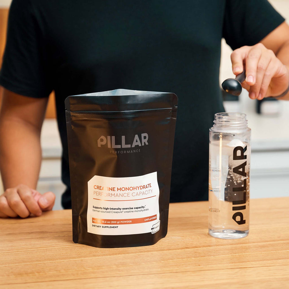 The PILLAR Performance Creatine Monohydrate - Unflavoured -  powder being tipped into water.